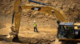 Excavator and construction worker carrying out environmental remediation work at a federal cleanup site.