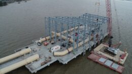 Large water intake pump station under construction beside a body of water