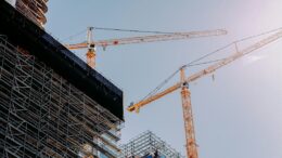 Illustrative construction cranes at a large urban building site; not one of the projects described in the briefing