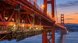 Illustration of construction crews working beneath the Golden Gate Bridge during seismic retrofit work